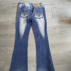 Blå bootcut jeans från Disinu - Snygga blå bootcut jeans från Disinu med tydlig kontrast. Jeansen har snygga detaljer på bakfickorna och är i bra skick!