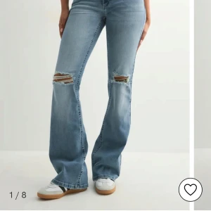 Ljusblå bootcut jeans med slitningar - Säljer ett par ljusblå bootcut jeans med snygga slitningar över knäna. Helt oanvända! I storlek 36
