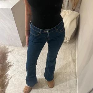 Flare low-waist jeans från H&M  - Säljer ett par klassiska blå jeans med flare-modell och low-waist. Jeansen har fem fickor, snygga kontrastsömmar och är tillverkade i ett mjukt denimtyg som sitter skönt. Perfekta för dig som gillar en tidlös look med lite utsvängda ben.