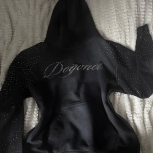 Svart/grå mjukis sett från Doganci - Svart grå sett från Doganci med glittrande strassdetaljer över hela och logga på ena benet. Byxorna har resår i midjan och är tillverkade i mjukt material som känns skönt mot huden. Använd 2 gånger, inga fel på den men har tröttnat.