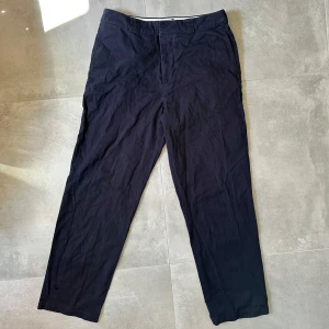 Mörkblå chinos från Arket i bomull - Snygga mörkblå chinos från Arket i 100% bomull. Klassisk rak passform med diskreta sidofickor och bakfickor. Perfekta för en clean och stilren look, lätta att matcha med det mesta. Sköna och luftiga, passar året runt. D1dp