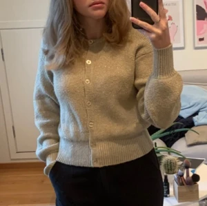 Beige stickad kofta från Bik Bok - Säljer en beige stickad kofta från Bik Bok i storlek S. Koftan har glittriga inslag, rund hals och knappar framtill. Ribbstickade muddar vid ärmslut och nederkant ger en snygg passform. Använd få gånger.💕☺️