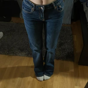 Blå bootcut jeans med fickdetaljer - Säljer ett par mörkblå jeans med bootcut passform och snygga fickdetaljer bak. Det är i väldigt bra skick MEN de är sönder (kolla bilderna) man kan fixa lätt med en svart tråd eller använda de för att sy en skinny jeans till en bootcut så säljer därför de för 139kr