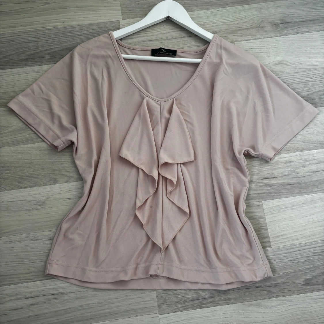 Ljusrosa blus med volang framtill