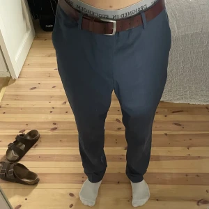 Mörkblå kostymbyxor med bälte - Blå kostymbyxor med klassisk rak passform från H&M. 