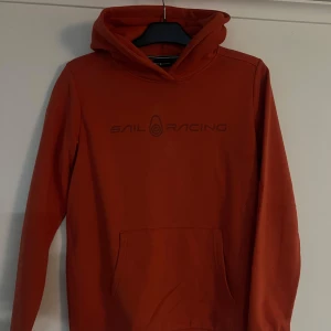 Hoodie från Sail Racing - Snygg orange hoodie från Sail Racing i jätte fint skick. Strl 170