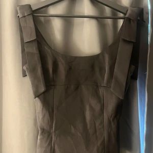 Svart topp - Fin svart topp med ”rosett” på axelbanden