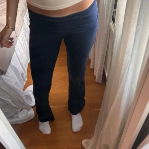 Mörkblå mjukisbyxor med låg midja - Säljer ett par mörkblå mjukisbyxor med låg midja och utsvängda ben. Byxorna är i mjukt och stretchigt material, perfekta för en chill och avslappnad stil. Passformen är loose och de sitter skönt över höfterna.