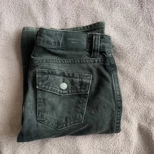 Mörkgråa flare/wide jeans från Gina Tricot - Mörkgråa low waist flare/wide jeans från Gina Tricot. Syns några tecken på användning.