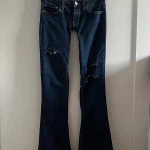 Low waist bootcut jeans - Säljer dessa väldigt low waisted jeansen med slitningar, egensydda, inga defekter!