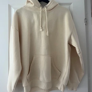 Gul hoodie med huva och ficka från BikBok - Säljer en gul hoodie med huva och dragsko. Tröjan har en stor magficka och ribbade muddar vid ärmslut och nederkant. Stor i storleken. 