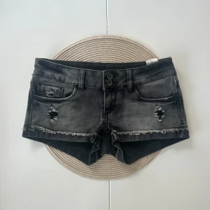 Lågmidjade jeansshorts  - Ett par lågmidjade jeansshorts i storlek 32 (XXS). Rakt över midjemått: 35cm. Längd: 19cm. Gren: 16cm. D16