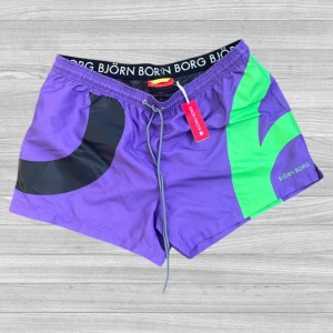 Björn Borg badshorts - Färgstarka badshorts från Björn Borg i lila med gröna och svarta grafiska detaljer. Shortsen har elastisk midja med snörning och svart resårband med logga. Perfekta för stranden eller poolen, riktigt sköna och snygga att bära hela sommaren.