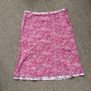 Rosa blommig kjol från Mexx - Supersöt kjol från Mexx i rosa och vitt med blommigt mönster. Kjolen är lätt utsvängd och har en fin kontrastkant längst ner. Tillverkad i bomull, perfekt för varma dagar när du vill känna dig både bekväm och snygg. Storlek 34.