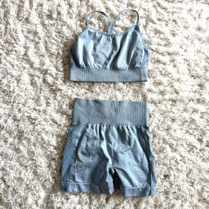 Ljusblått träningsset  - Säljer detta träningsset, shorts med hög midja och ribbade detaljer längs sidorna med en matchande topp. Stretchiga och sitter skönt på kroppen, perfekta för gymmet eller yoga. Materialet är mjukt och andas! 