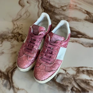 Rosa valentino flycrews  - Valentino flycrew skor rosa glitter, ingen bag osv följer med då jag köpte dom här på Plick och inte fick det, på ena skon saknar dem 2 nit medan på andra skon saknar dem 3 nitar. Säljer pågrund av att skorna är förstora för mig. Pris kan diskuteras, skriv privat för mer bilder eller liknande. 