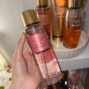 Victoria's Secret Strawberries & Champagne - Fräsch body mist från Victoria's Secret i doften Strawberries & Champagne. Flaskan är genomskinlig med rosa etikett och guldigt lock. Innehåller 250 ml och har en söt, bubblig doft av vilda jordgubbar och mousserande champagne. Perfekt för dig som gillar fruktiga och lyxiga dofter. Helt oanvänd som man ser på bilden. Kvitto finns.