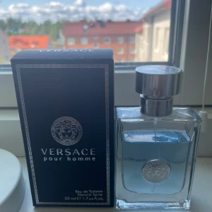 Versace Pour Homme EdT - Fräsch och citrusfrukter parfym från Versace som kallas Pour Homme. Flaskan är stilren i genomskinligt glas med ljusblått innehåll och silverfärgad metallkork. Med klassisk Versace Medusa-logga på både flaska och  kartongen. 50 ml spray. Köpt på Parfym.Se och användas fåtal gånger.