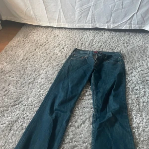 Levis 514 blå jeans bootcut - Säljer ett par klassiska Levis 514 jeans i blå denim. Modellen har bootcut-ben och normal passform, med fem fickor och snygga kontrastsömmar. Jeansen har låg midja och är tillverkade i slitstarkt material. Knappt använda alls därför i mycket bra skick! Midjemått: 42cm rakt över Innerbenslängden: ca 75cm skulle säga s/m
