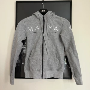 Grå hoodie från Maya delorez med dragkedja - Snygg grå sip up hoodie från Maya delorez i väldigt bra skick!