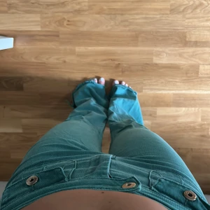 Turkosa bootcut manchesterbyxor - Turkosa jeans med bootcut och låg/mellan midja. Byxorna har två framfickor med knappar och coola detaljer. Superbra skick! 