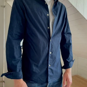 Mörkblå skjorta från MNG - Nice mörkblå skjorta från MNG i snygg modell! Skjortan har klassisk krage, vita knappar och långa ärmar! Nytt skick! 