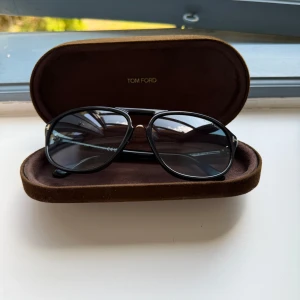 Tom Ford solglasögon - Snygga svarta solglasögon från Tom Ford, modell Jacob TF447. Klassisk pilotform med svarta bågar och mörka tonade glas. Alla originalsaker hänger med köpet, inga defekter osv de är i bra skick. Inte använda super mycket och säljer pga att jag fått ett par nya. Tveka inte att höra av er! Kan justera priset lite vid snabb affär!