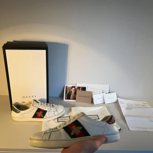 Gucci Ace Bee - Tja! Säljer nu dessa riktigt feta Gucci Ace Bee skor! De är lite slitna, men annars väldigt bra skick och kritvita. Jag skulle säga att skicket är 7/10 just eftersom det är bara några få repor i lädret men annars jättebra skick. Storlek: 7,5 US, eller ca 40 - 41 EU👟. Nypris: 5000kr❌‼️ Mitt pris: 2399✅Allt OG följer med! Tveka inte att kontakta mig om du har frågor!🤝