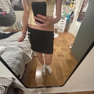 Svart kortkjol med rosetter NLY One - Svart kortkjol från NLY One i storlek S 💞💘 Kjolen har två vita, transparenta rosetter på sidan som ger en söt och trendig ✌️väldigt bra skick, knappt använd  💞Perfekt för dig som vill ha en basic mini kjol med lite extra 💘✌️