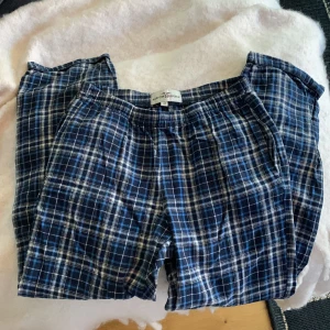 Blårutiga mjukisbyxor Hampton Republic - Blårutiga mjukisbyxor från Hampton Republic med elastisk midja. Byxorna har ett klassiskt rutmönster i blått och vitt och är tillverkade i mjukt bomullstyg. Perfekta för chill dagar hemma eller som mysplagg.