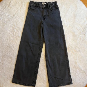 Svarta wide jeans från Lindex - Snygga svarta jeans från Lindex med hög midja och raka, vida ben. Jeansen är i ett mjukt denimtyg och passar perfekt till en avslappnad stil.