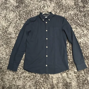 Mörkblå skjorta från Jack and Jones.  - Stilren mörkblå skjorta från Jack and Jones. Storlek är egentligen 164 men sitter större som en xs. Ställ gärna frågor. Priset kan diskuteras 