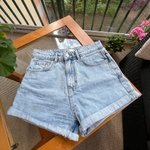 Ljusblå jeansshorts från gina tricot perfect jeans - Ljusblå jeansshorts med klassisk femficksdesign och uppvikta benslut. Storlek 36. 