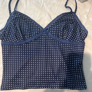 Prickig topp - Supersöt mörkblå topp med vita prickar och tunna axelband. Aldrig använt! Skriv för mer frågor💕skulle säga att storleken är M men passar S