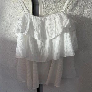 Vit volangig linnetopp - Supersöt vit linnetopp med tunna axelband och flera lager volanger. Jätte snygg nu till sommaren 💓
