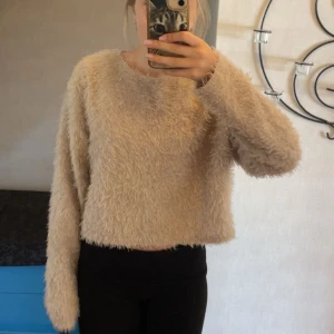 Beige fluffig tröja från Nelly - Supermjuk och fluffig beige tröja från NELLY. Tröjan har lång ärm, rund halsringning och en loose fit som ger en härlig känsla. Storlek M men passar även XS/S utan några konstigheter! Skulle säga att den snarare är S. Tröjan är otroligt mjuk och skön, känns som att man går runt med en mysig filt. Inte alls stickig!🤍