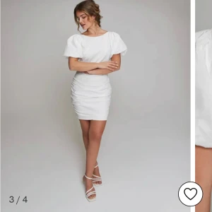 Vit kort klänning från Nelly - Superfin vit kort klänning från Nelly med puffärmar, rynkade detaljer och öppen rygg. Klänningen har en figurnära passform och är perfekt för dig som vill sticka ut. Materialet känns lätt och fräscht, och den har en snygg rund halsringning framtill. Den är helt ny och aldrig använd, och helt slutsåld 💗