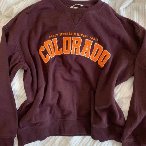 Vinröd tröja från H&M - Säljer denna fina vinröda tröja med trycket Colorado från H&M. Storleken är M. Har inga tecken på användning. Säljer för den inte kommer till användning längre :)