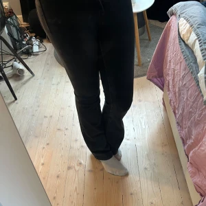 Svarta bootcut jeans från H&M Divided - Säljer ett par svarta bootcut jeans från H&M Divided i storlek 36. Jeansen har klassisk femficksdesign, normal passform över låren och utsvängda ben. Materialet är mjukt och stretchigt för en bekväm känsla. Perfekta till sneakers eller boots.