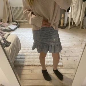 Blåvit randig kjol från Gina Tricot - Supersöt blåvit rutig kjol från Gina Tricot med volang nertill. 