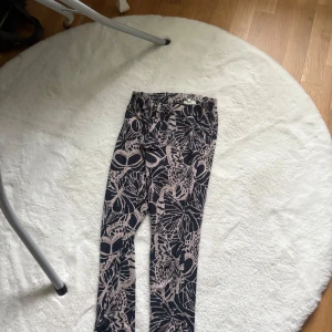 Svarta leggings med blommigt mönster - Snygga svarta mjukisbyxor med blommigt mönster . Perfekta för dig som vill sticka ut med coola detaljer och mönster. Passar till både oversized hoodie eller crop top.