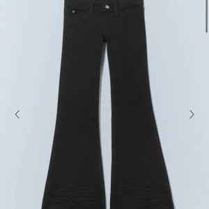 Svarta lågmidjade jeans med bootcut  - Säljer ett par svarta bootcut jeans med låg midja. Perfekta att styla med bälte och sneakers för en cool look. Dessa är de populära jeansen från Weekday i modellen FLARE LOW WAIST FLARED SKINNY JEANS. Säljer för 350kr
