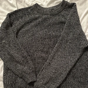 Mörkgrå stickad tröja - En chunky, mörkgrå stickad tröja med grov struktur och långärmad modell. 