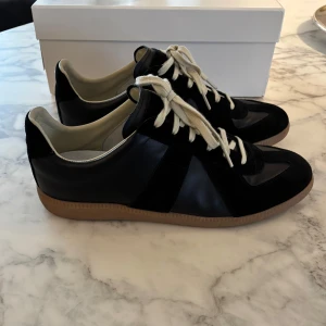 Maison Margiela GATS - Svarta Maison Margiela sneakers i storlek 43. Skorna är endast använda ett fåtal gånger och är i mycket bra skick.