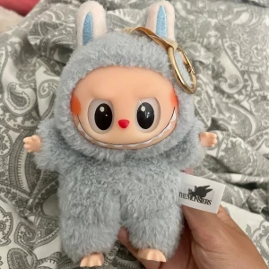 Äkta labubu! 💙 - En söt och fluffig Labubu nyckelring/docka från The Monsters by Pop Mart, den är i färgen sea salt alltså den blåa. Perfekt som accessoar till väskan eller som samlarobjekt för dig som gillar unika och trendiga figurer. Säljer på grund av att jag har en till som jag gillar färgen på mer och har inget behov av att ha två! 💕💕
