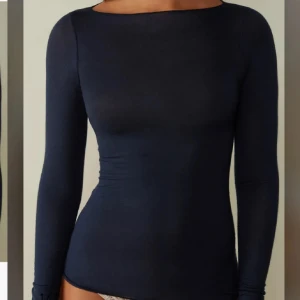Mörkblå långärmad topp - Snygg mörkblå långärmad topp med tight passform och rund halsringning. Tröjan är väldigt tunn vilket gör att man ser in rätt mycket - däremot är det en basic men snygg tröja 