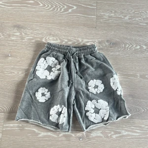 Grå shorts från Denim Tears - Jag säljer dessa gråa denim tears shorts. Shortsen är helt nya med prislapp och säljs för ett väldigt bra pris. Skulle du vela diskutera pris eller snacka om några konstigheter är det bara att hojta!😄 