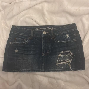 American eagle jeanskjol med slitningar - Skit snygg jeanskjol med slitningar och glitter detaljer ifrån American eagle , aldrig använd därav inga defekter och i nyskick ☺️