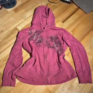 Rosa hoodie från Esprit - Säljer en snygg rosa hoodie från Esprit med dragkedja och blommigt mönster på framsidan. Den är i bra skick förutom små färgfläckar på framsidan (se bild) är dock ganska säker på att dom går att får bort! Hör av dig vi frågor!🫶