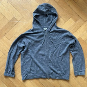 Grå hoodie från Soft Goat - Säljer en stilren grå hoodie från Soft Goat i storlek S. Den är tillverkad i mjukt material och har en praktisk dragkedja framtill. Perfekt för en avslappnad look.